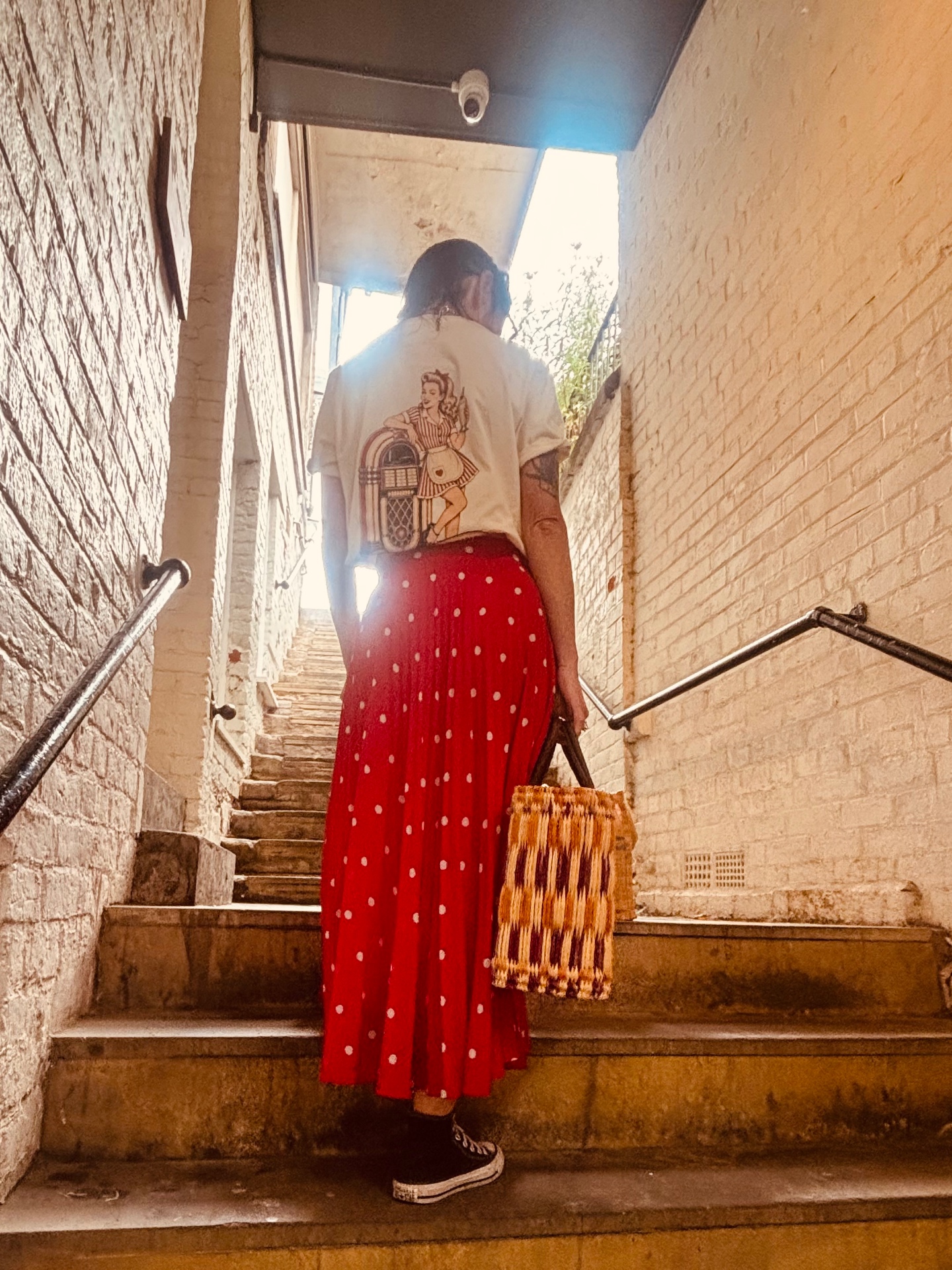 Shake Rattle & Roll raglan tee back print with red polka dot skirt on vintage steps