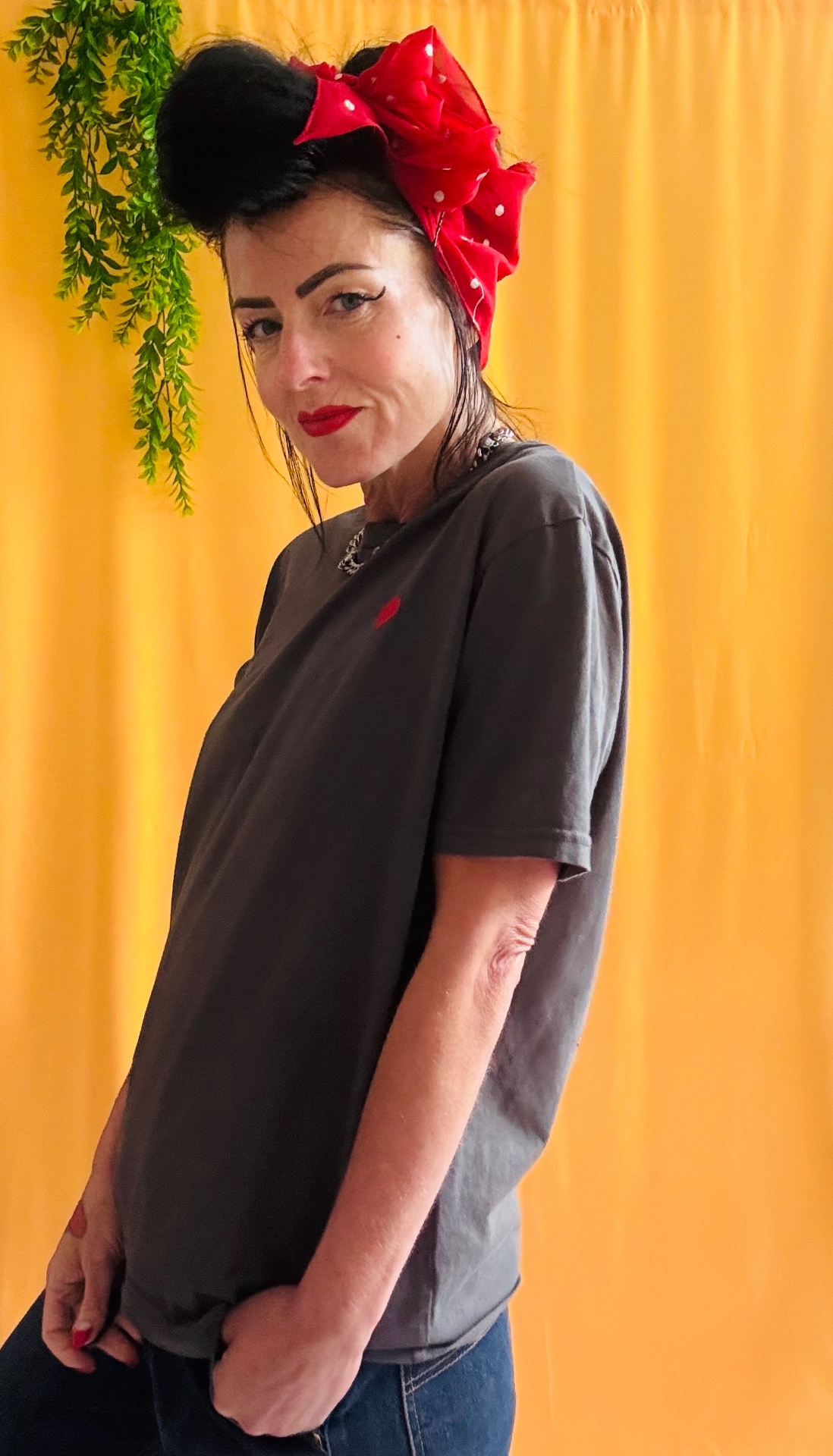 Bottoms Up Darlings tee side view showing the relaxed fit on yellow backdrop